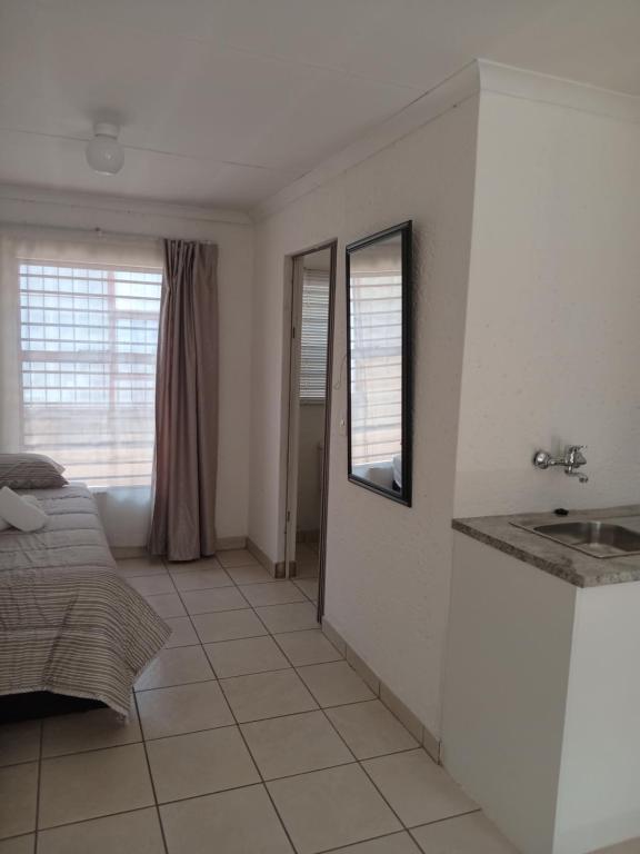 a room with a sink and a bed in it at Baksman's Retreat in Soweto