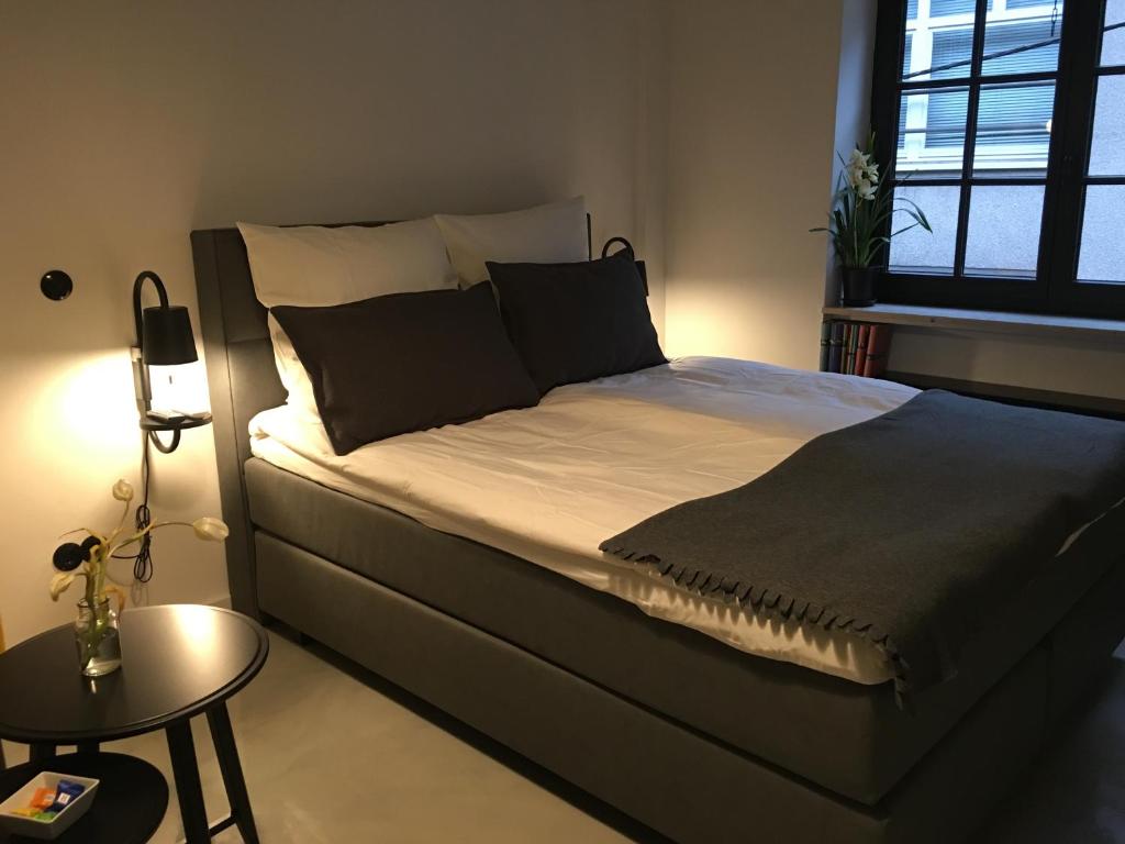 a large bed in a bedroom with a table at Square Rooms 8 in Düsseldorf