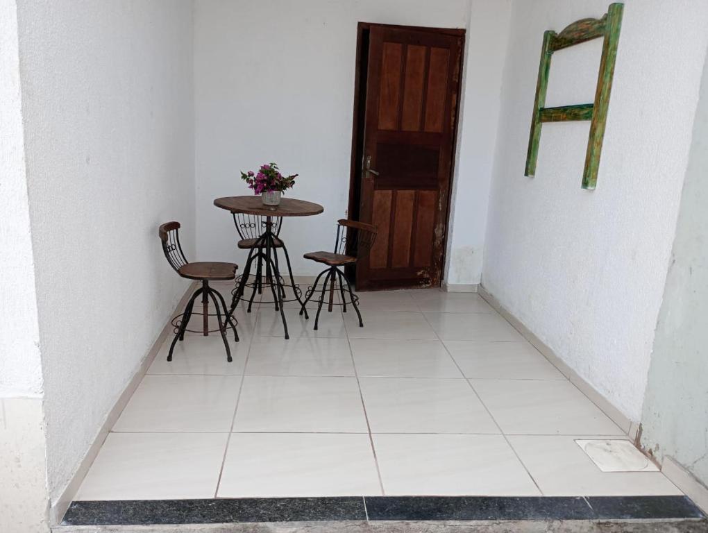 uma sala com uma mesa e cadeiras e uma porta em Nosso Sonho em Rio das Ostras