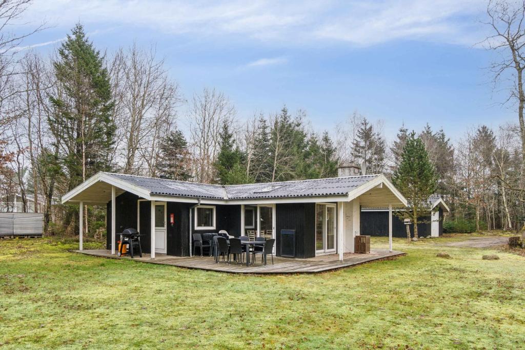una piccola casa con portico e terrazza di Cozy Cottage Near Limfjorden a Roslev