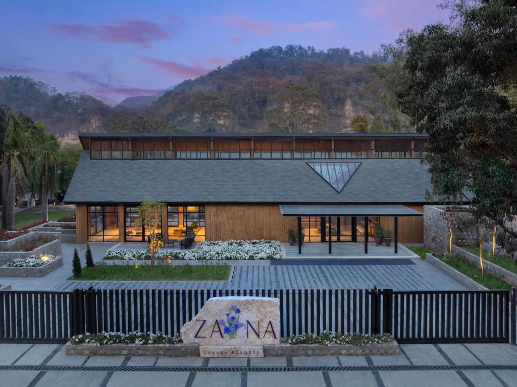 un grande edificio con una montagna sullo sfondo di ZANA Luxury Suites and Cottages, Dhikuli, Jim Corbett a Ramnagar