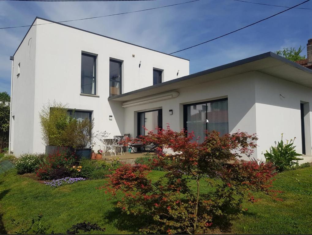 une maison blanche avec un jardin en face dans l'établissement Maison contemporaine 3 chambres, à Anglet
