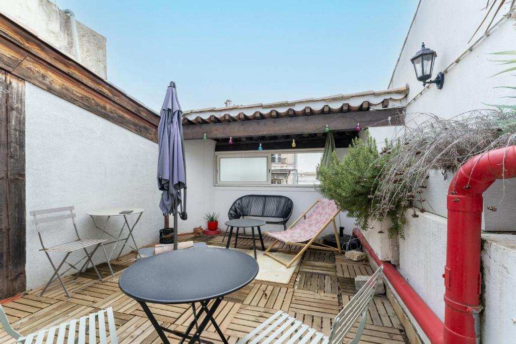 un patio avec une table, des chaises et un parasol dans l'établissement Au Coeur D'avignon, à Avignon
