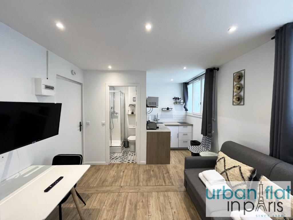 un salon avec un canapé et une table dans l'établissement 183 - Villette Studio, à Paris