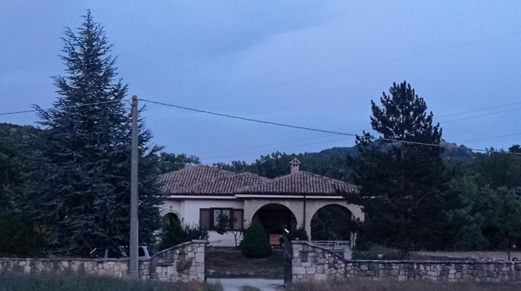 une maison blanche avec une arche et une clôture dans l'établissement La depandance, à Castel di Sangro