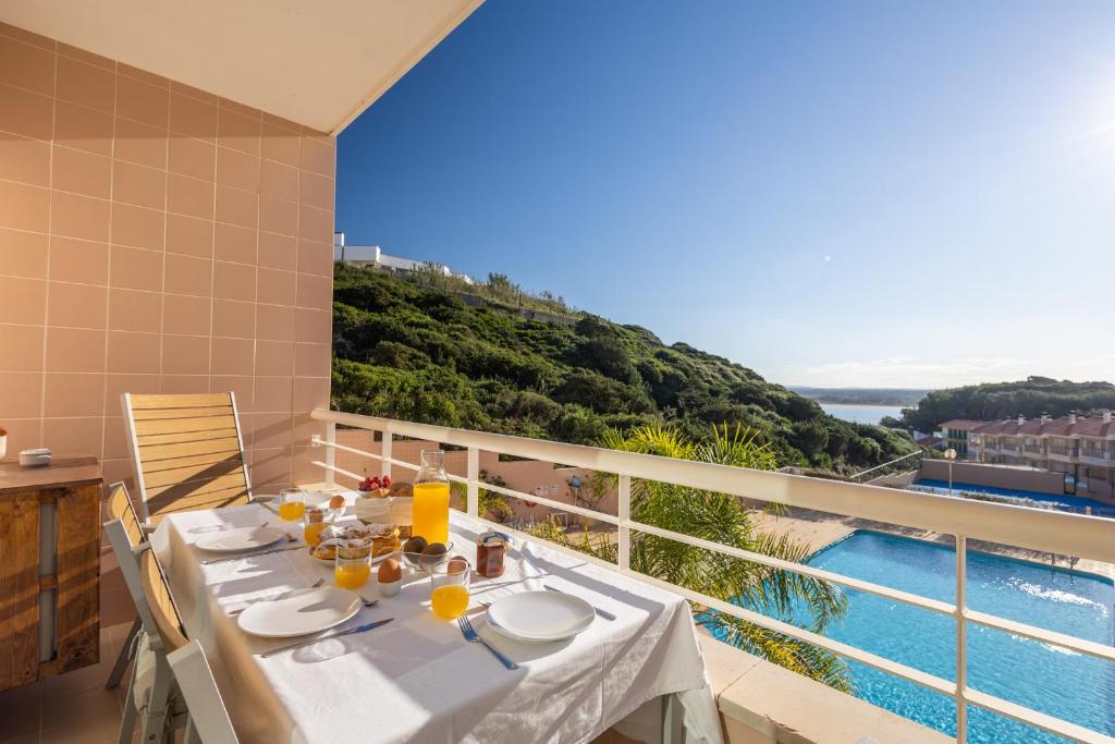 een eetkamer met een tafel en uitzicht op het water bij Bay View T1 - By Smarthomes in São Martinho do Porto
