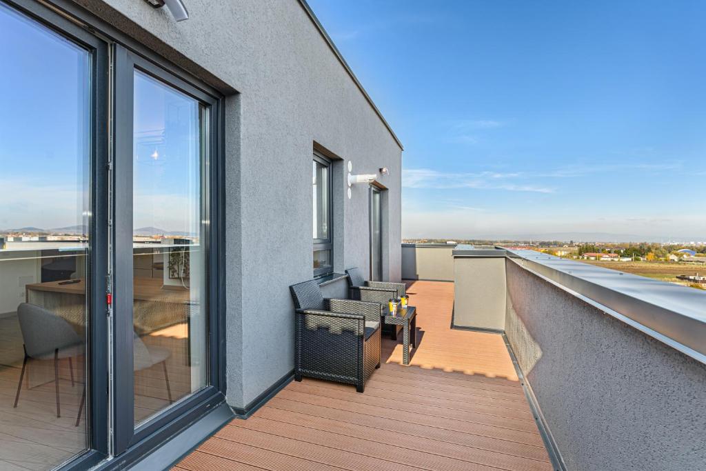 un balcon avec une table et des chaises sur un immeuble dans l'établissement KOA - THE BOX, à Braşov