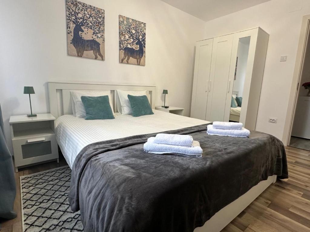 a bedroom with a large bed with towels on it at Apartament 2 Cam Cetate in Alba Iulia