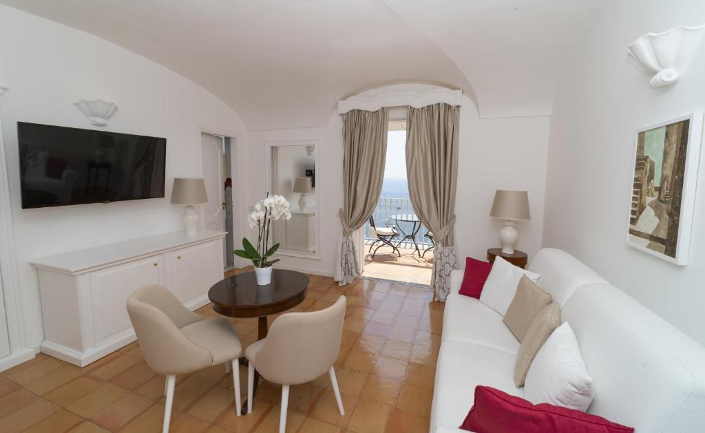 a living room with a white couch and a table at Hotel Marincanto in Positano