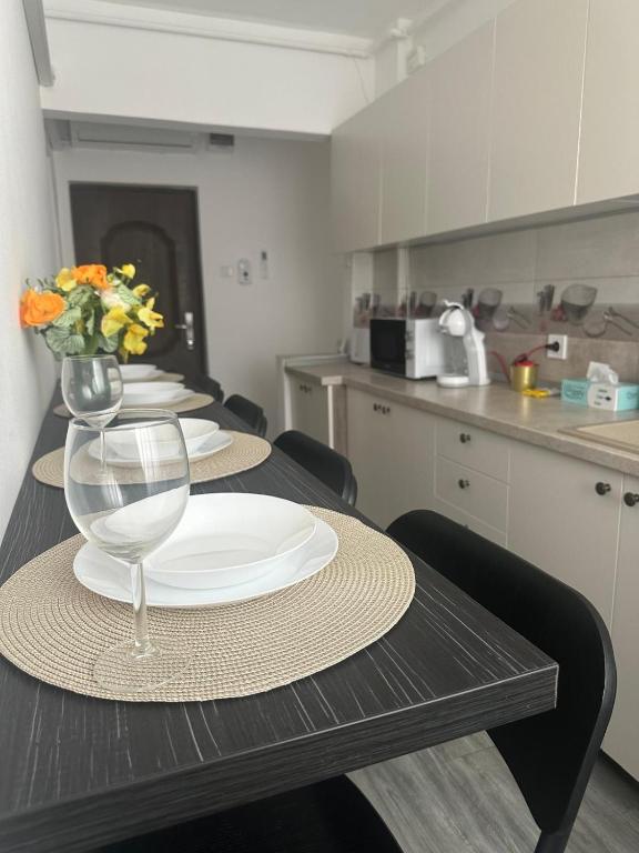 a table with plates and a vase of flowers on it at Apartament 2 Cam Cetate in Alba Iulia
