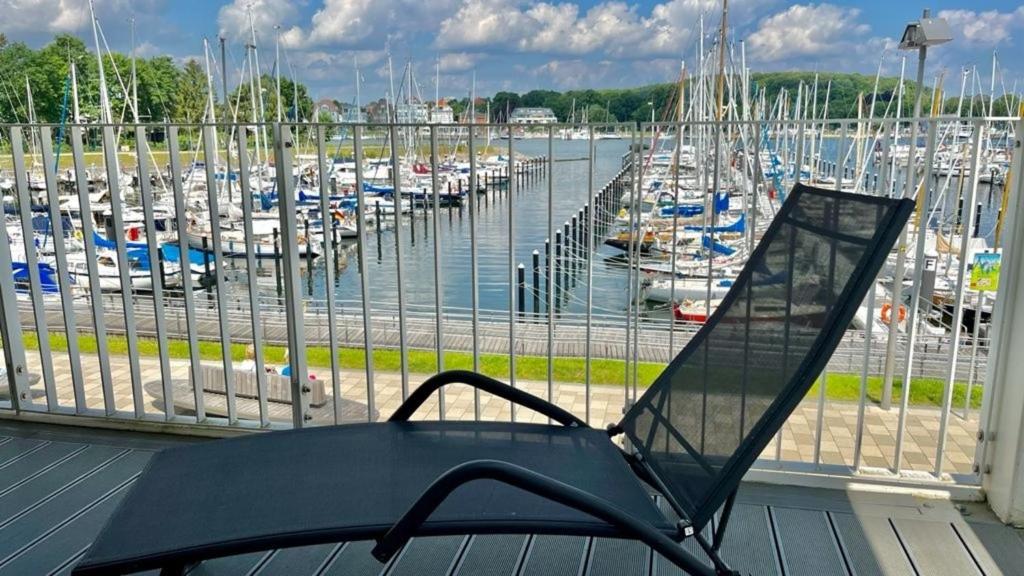 a chair sitting on a porch overlooking a marina at App 22 3-Zi Whg "Hafenblick" am Passathafen PVA022 in Travemünde