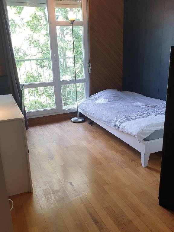 une chambre avec un lit et une grande fenêtre dans l'établissement 14 allée du Gacet, à Rennes
