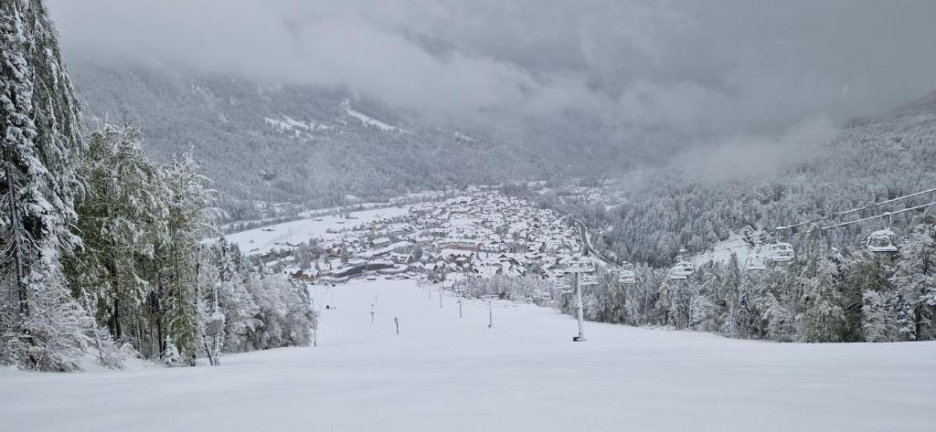 una pista de esquí cubierta de nieve con una ciudad a lo lejos en Apartment Brina, en Kranjska Gora
