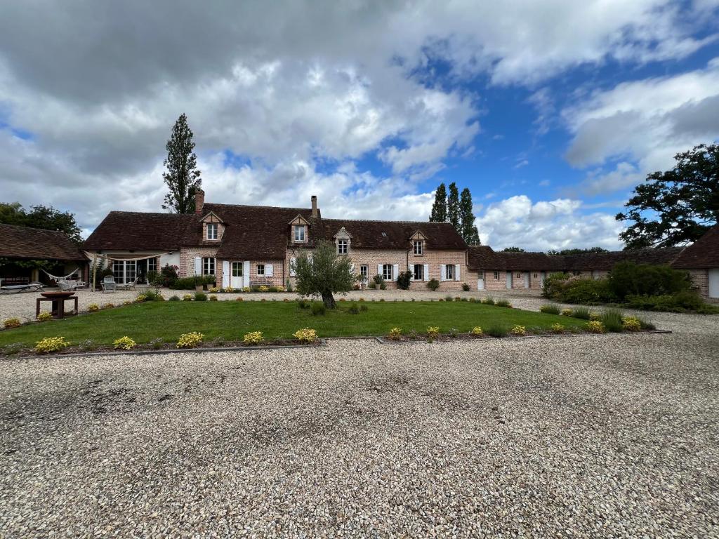une grande maison avec une allée en gravier dans l'établissement Fabuleuse propriété XVIIISologne14 pers Piscine, à Montrieux-en-Sologne