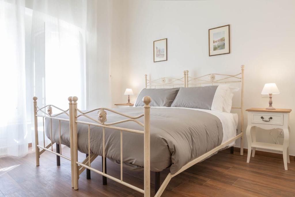 a white bedroom with a bed with a metal frame at Donna Margherita Rome Suite & Rooms in Rome
