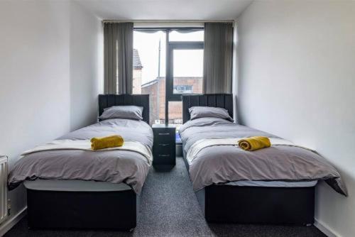 two twin beds in a room with a window at Charming 1-bed Flat in Eastwood in Eastwood