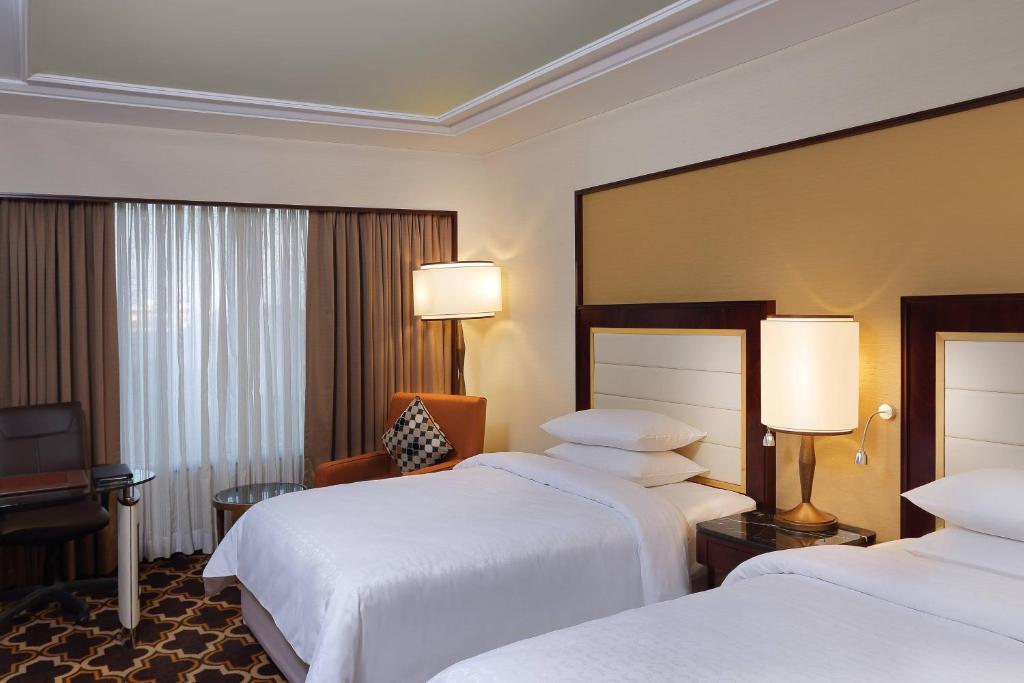 Postel nebo postele na pokoji v ubytování Sheraton Grand Pune Bund Garden Hotel