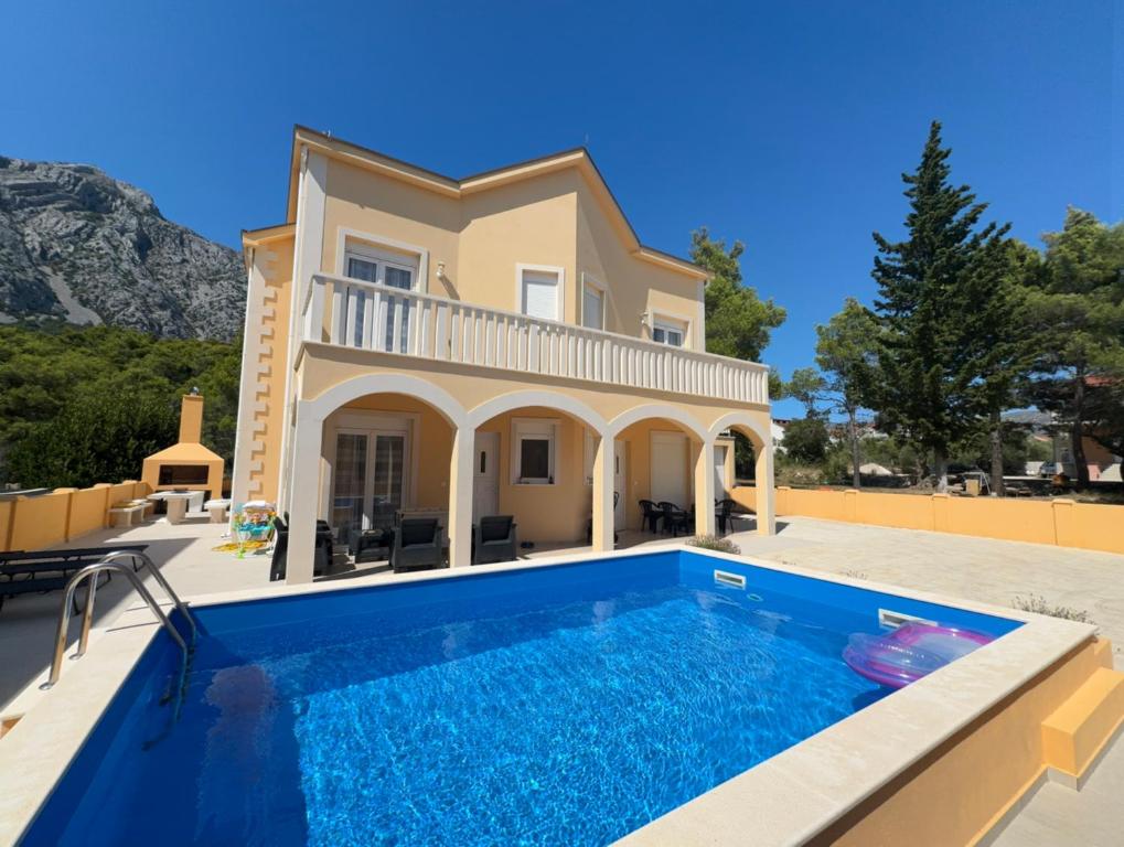 a villa with a swimming pool in front of a house at Villa Sunshine in Orebić