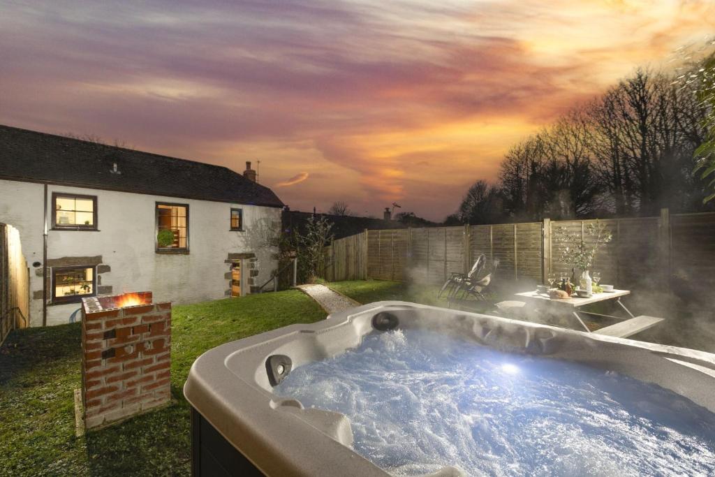 a hot tub in the yard of a house at The Old Hay Barn, Croft Hooper in Ludgvan