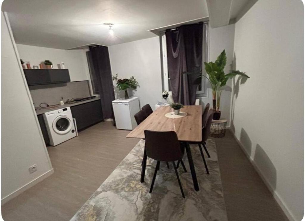 un salon avec une table et une cuisine dans l'établissement Appartement centre ville, à Avignon