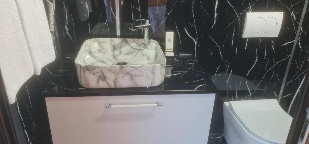 a bathroom with a white sink and a toilet at Shtepiza Lio liqeni merhojes in Belsh