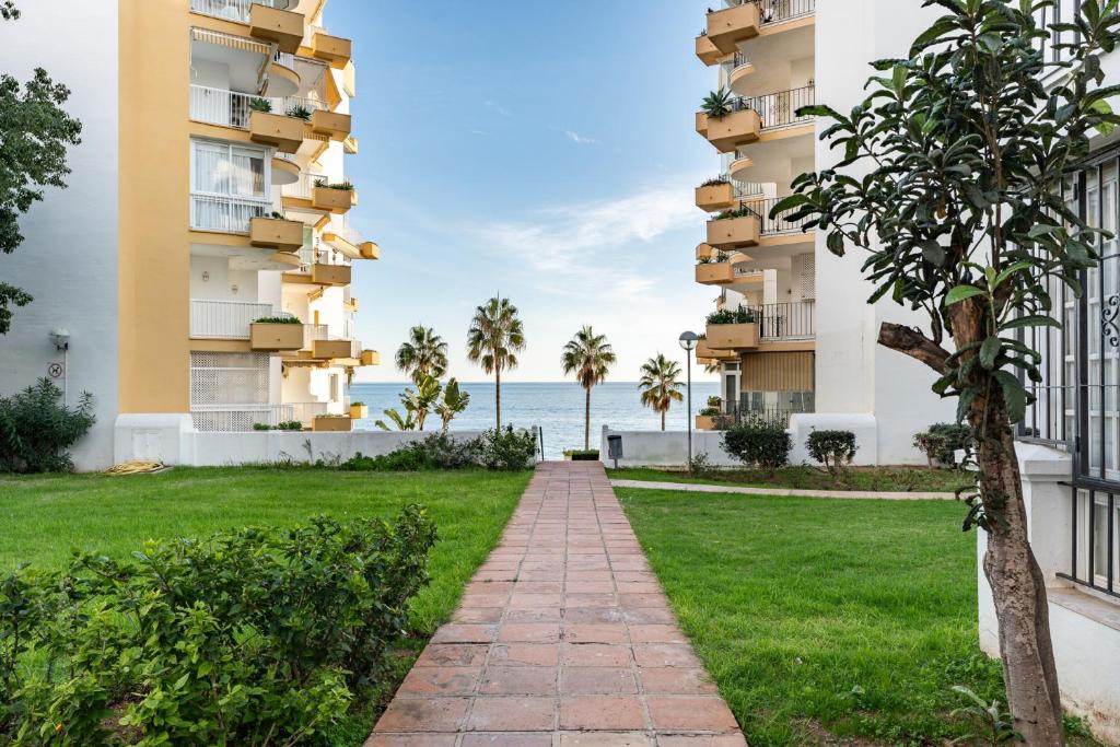 einen Gang zwischen zwei Apartmentgebäuden mit dem Meer im Hintergrund in der Unterkunft CT 350 - Faro's Marbella Beachapartment - perfect beachconection in Marbella
