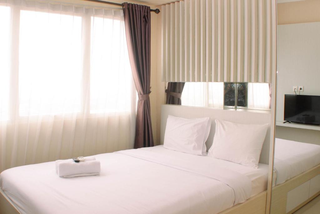 芝卡朗Cozy and Comfort Living 1BR at Oasis Cikarang Apartment By Travelio的一间卧室配有一张带白色盒子的床