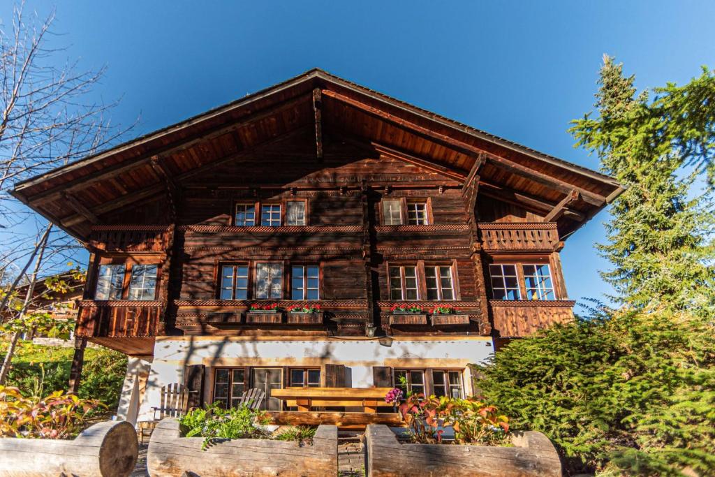 a large wooden house with a bench in front of it at Chalet Ruthchen in Grindelwald