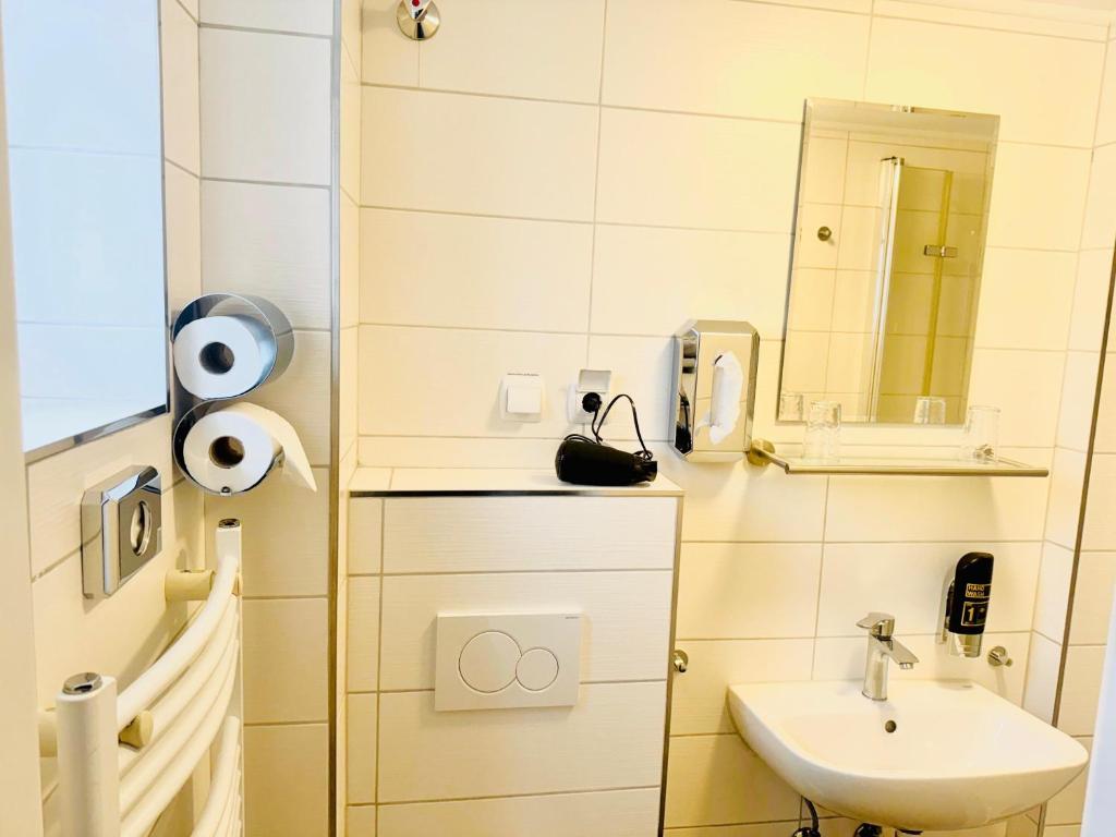 a small bathroom with a sink and a mirror at Hotel Soad in Salach