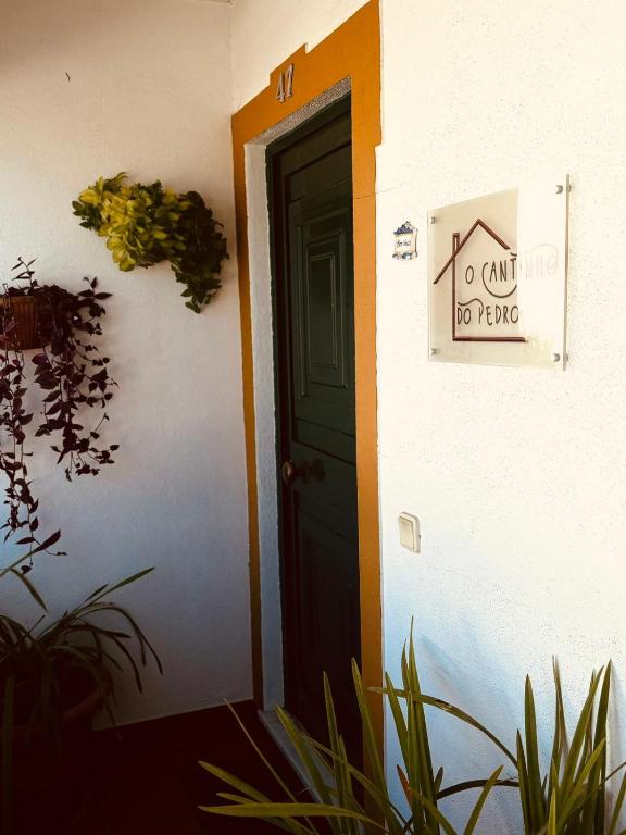 a door with a sign on the side of a building at O Cantinho do Pedro in Tolosa