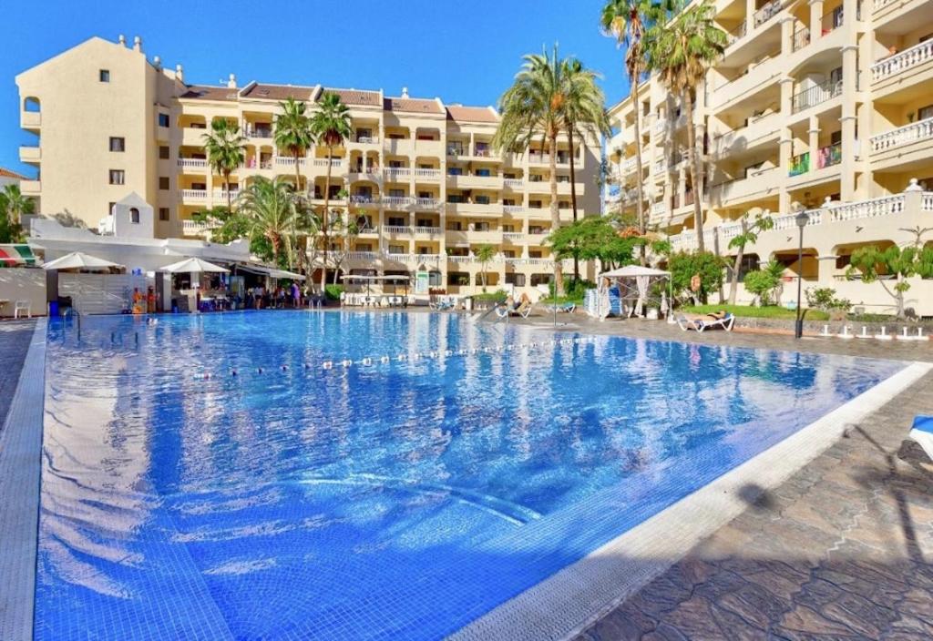 a large swimming pool in front of a hotel at The Poolside Haven, Azure Dreams in Los Cristianos