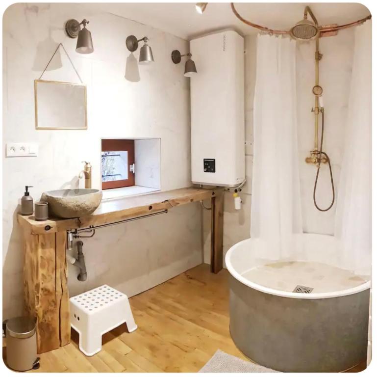 La salle de bains est pourvue d'une grande baignoire et d'un lavabo. dans l'établissement Gîte du rucher, à Saint-Quintin-sur-Sioule