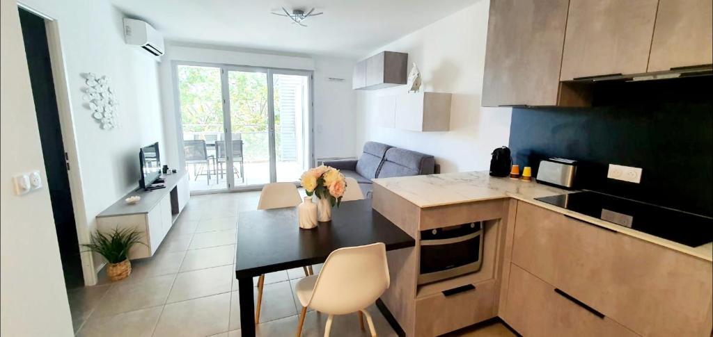 - une cuisine avec une table et des fleurs dans l'établissement O'Cap, à Antibes