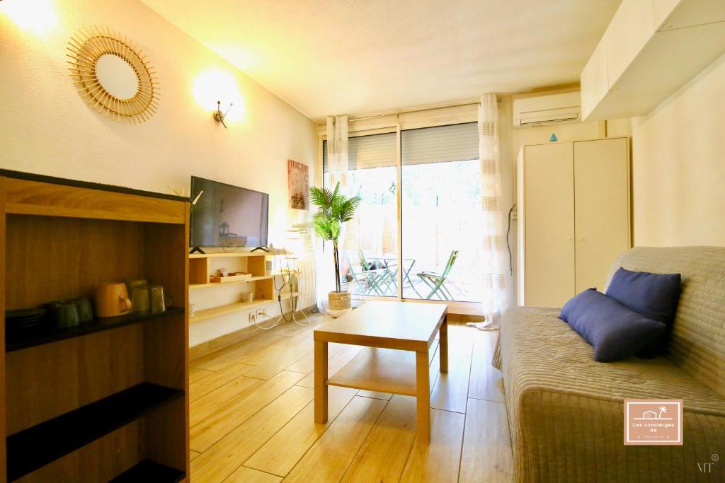 un salon avec un canapé et une table dans l'établissement Le Kanumera, piscine et clim, à La Seyne-sur-Mer