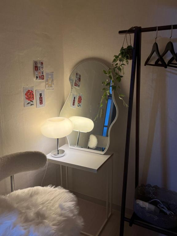 Habitación con mesa, espejo y lámpara. en Cozy guesthouse, 10 minutes from SNU Entrance Station, accommodation in Sharosu-gil, OTT, Nespresso machine, within 25 minutes by subway to Hongdae, Gangnam, Seongsu, Gwanaksan, up to 5 people, en Seúl