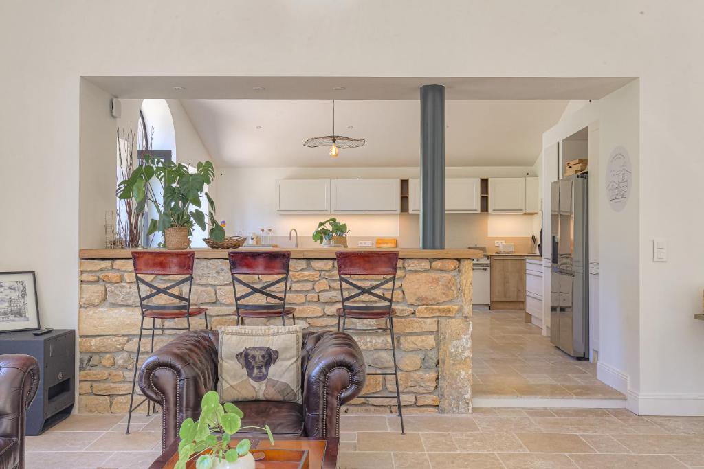 Il comprend une cuisine et un salon avec un mur en pierre. dans l'établissement Cuvage des Pierres Dorées - Beaujolais, à Denicé