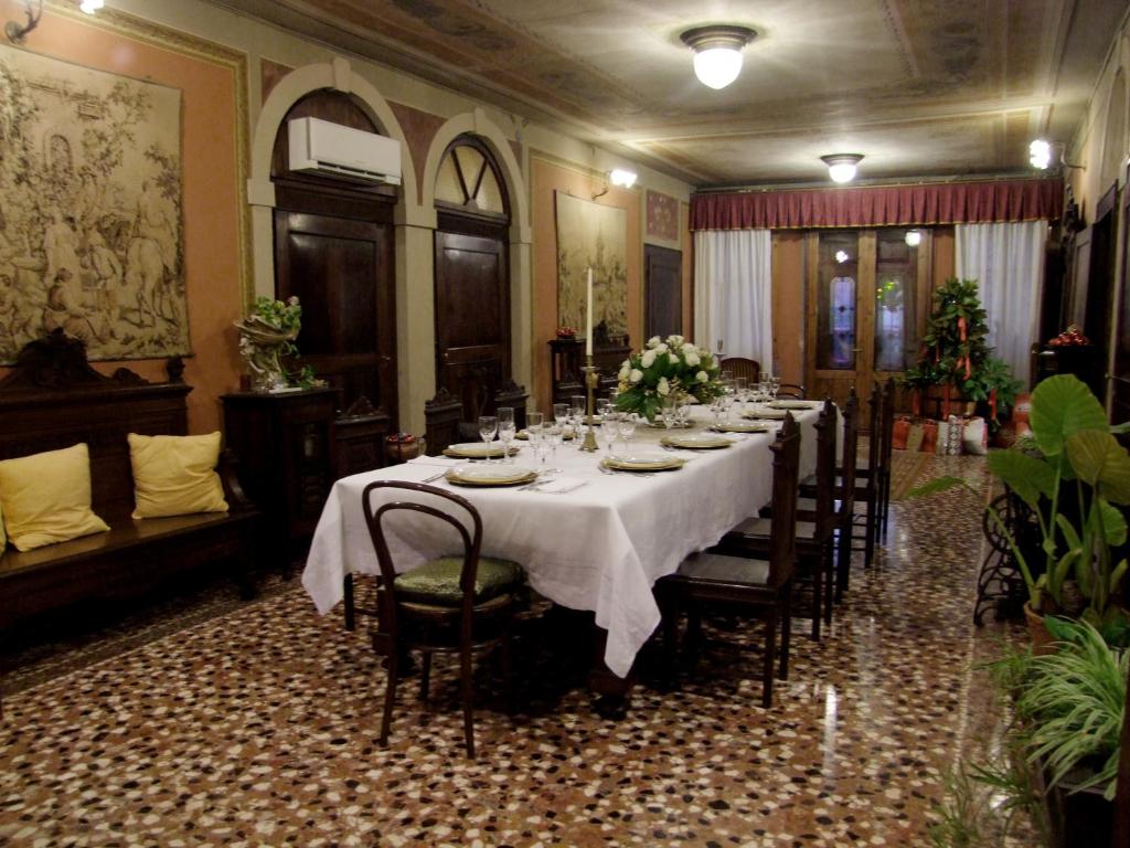 un comedor largo con una mesa larga y sillas en B&b Villa Bornancini, en Cinto Caomaggiore