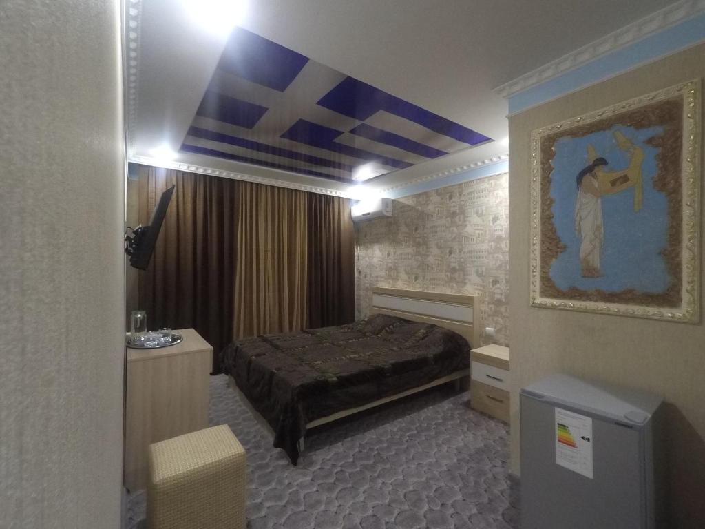 فندق أوليمب في أَورينبورغ: غرفة نوم بسرير ودهان على الحائط