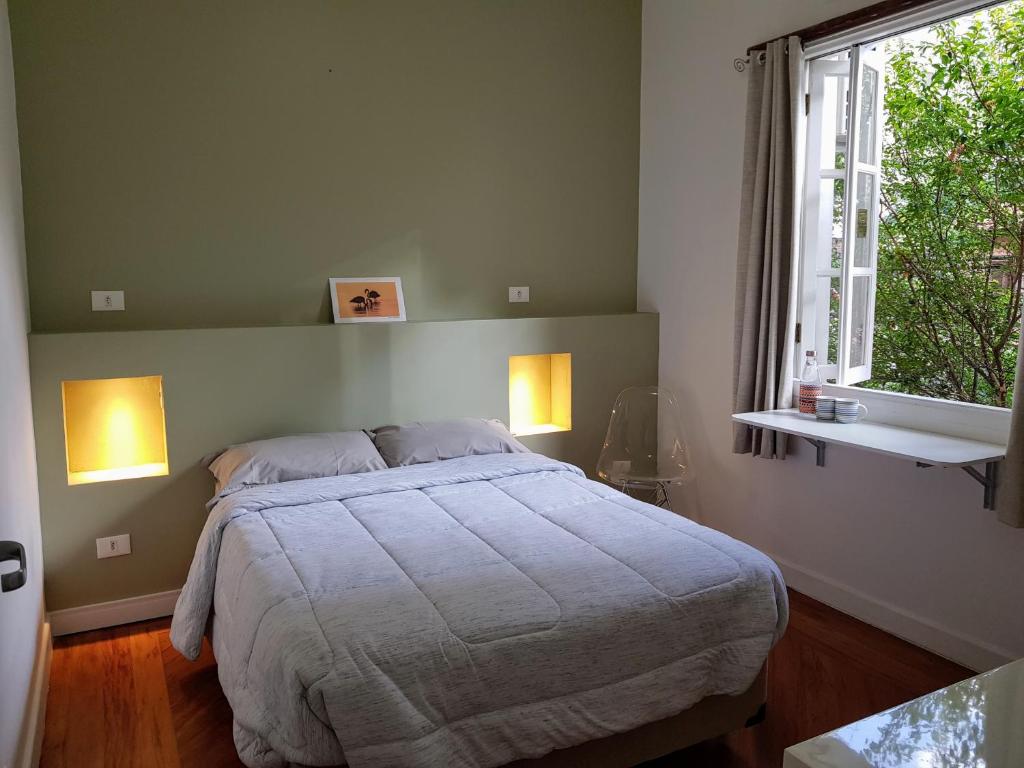 a bedroom with a bed and a window at Casa Saint Hilaire in Sao Paulo