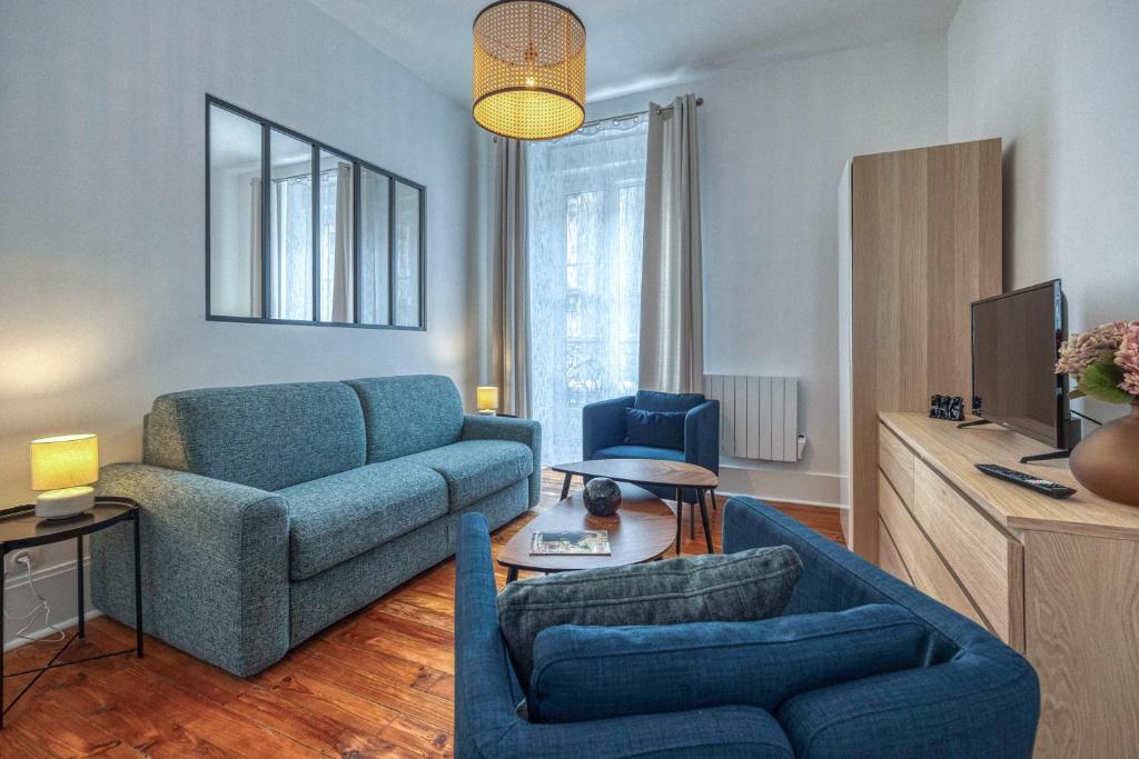 un salon avec un canapé bleu et une chaise dans l'établissement Le Marx - Cours Berriat, à Grenoble