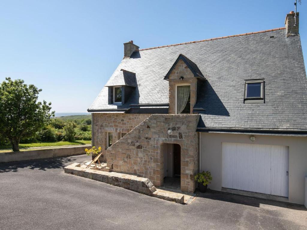 een groot bakstenen huis met een witte garage bij La Maison de Saint-Hernot in Crozon