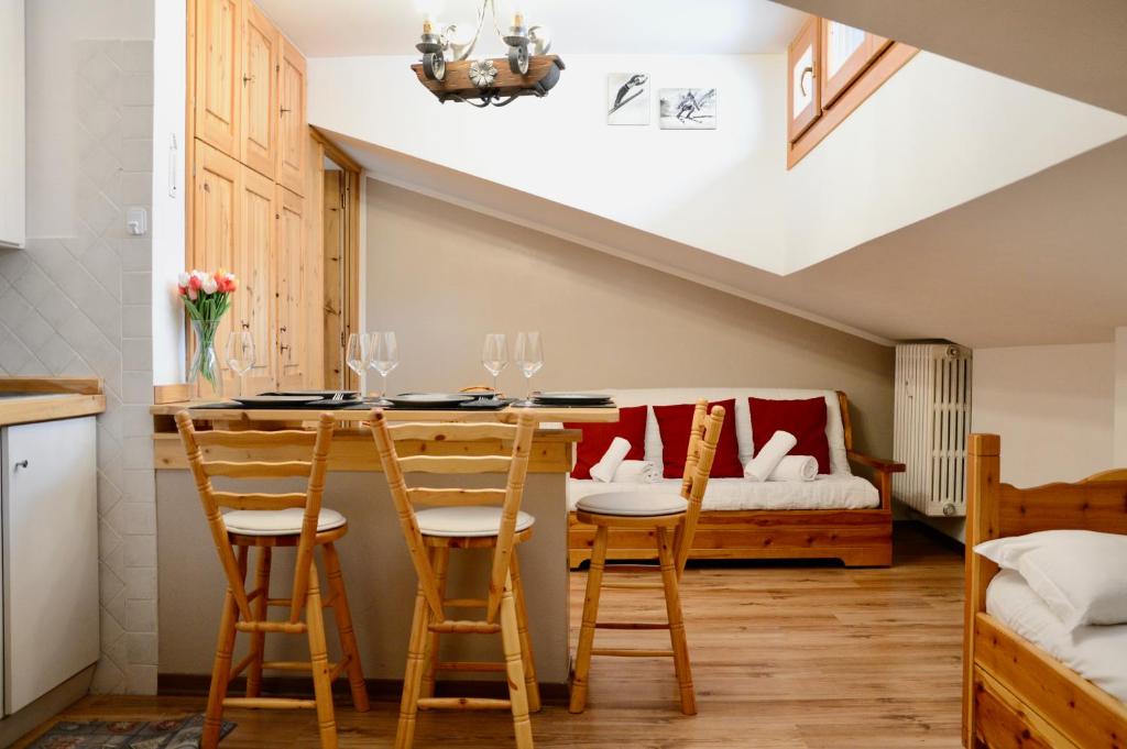 une pièce avec une table et des chaises et une chambre dans l'établissement Hostdomus - Rifugio delle Stelle, à Sestrières