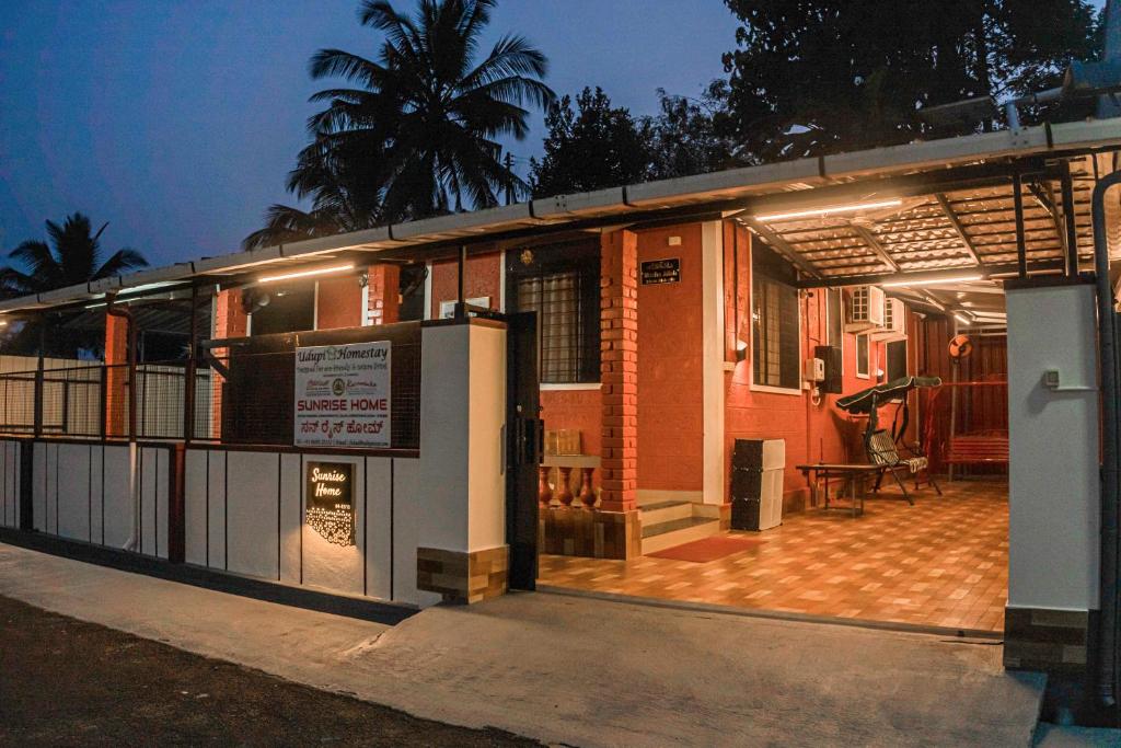 a building with a porch with a sign on it at UDUPI HOMESTAY - Sunrise Home in Udupi