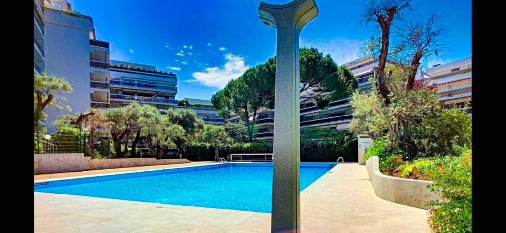 une piscine avec un poteau en face d'un bâtiment dans l'établissement Ref TANIT by Palmes dProperties, à Juan-les-Pins