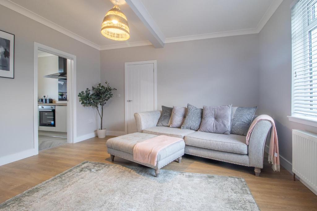 a living room with a couch and a ottoman at Westlea House in Airdrie
