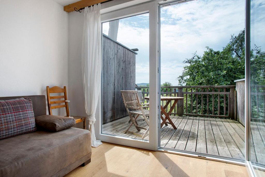 a living room with a couch and a sliding glass door at Kombi Wohnung in Deggenhausertal