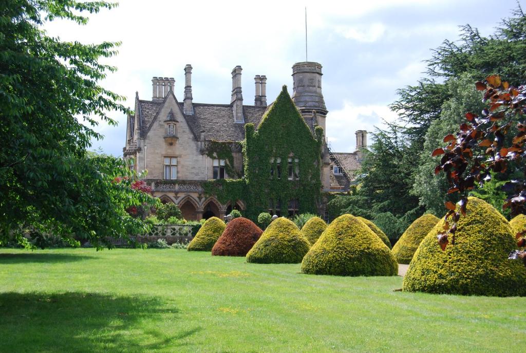 a house with a bunch of bushes in front of it at Manor by the Lake in Cheltenham