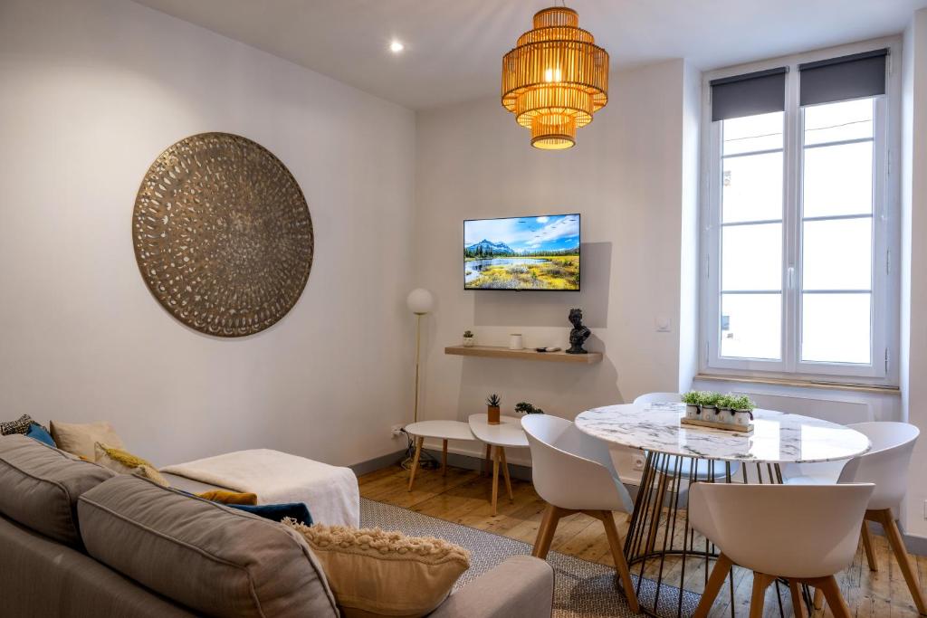 a living room with a couch and a table at Major d'Home Amalgame avec jacuzzi en option in Périgueux