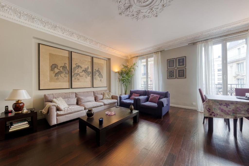 un salon avec un canapé et une table dans l'établissement Georges V Champs-Élysées Escapade Familiale, à Paris