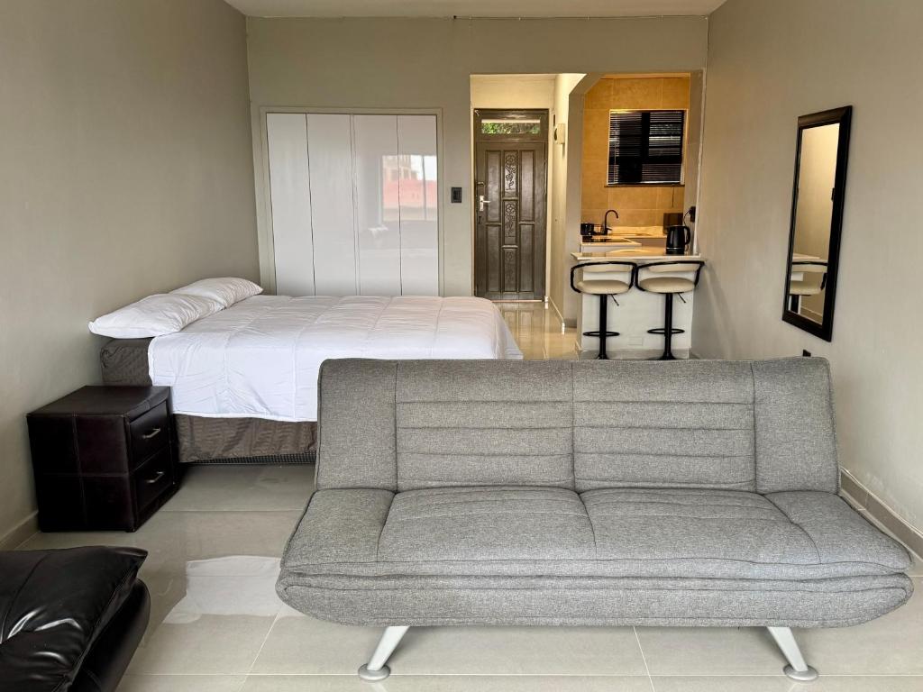 a living room with a couch and a bed at Ridge Royal in Amanzimtoti